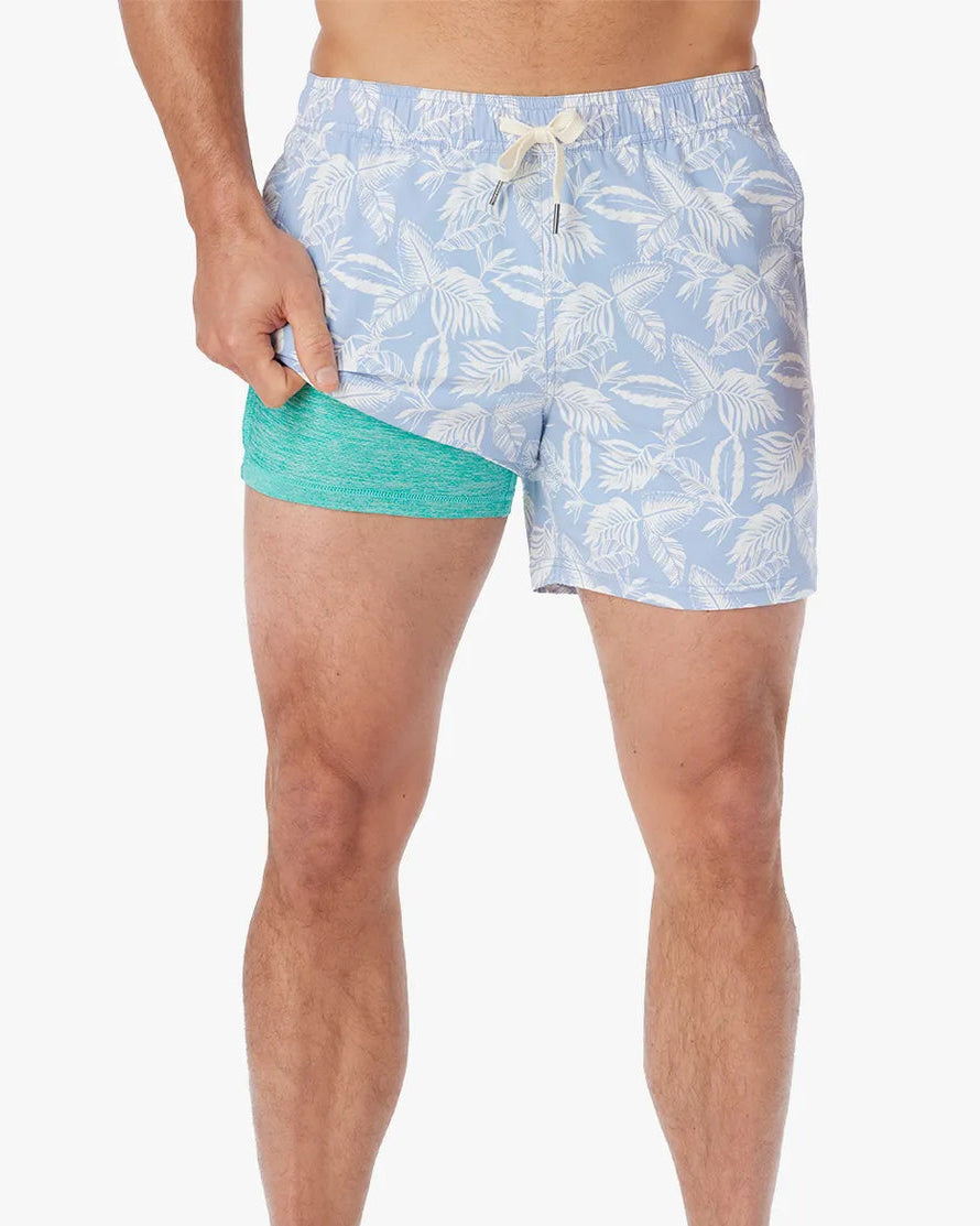 Person wearing light blue swim shorts with a pattern on a white background