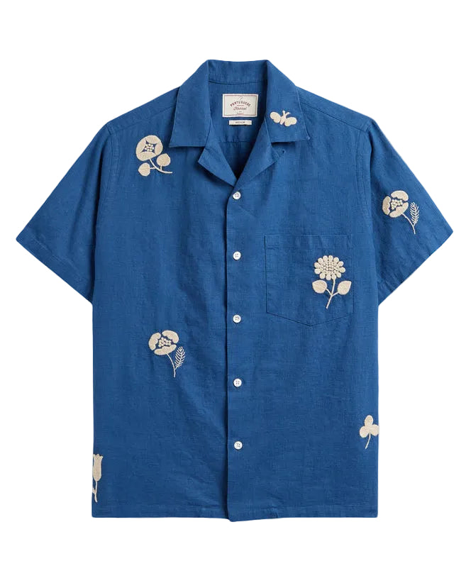 Blue shirt with floral embroidery on a beige background