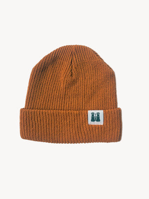 Orange knit beanie with a logo on a white textured background
