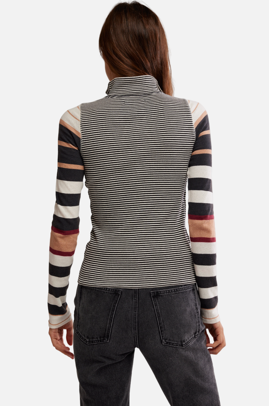 Person wearing a striped long-sleeve top with a plain background