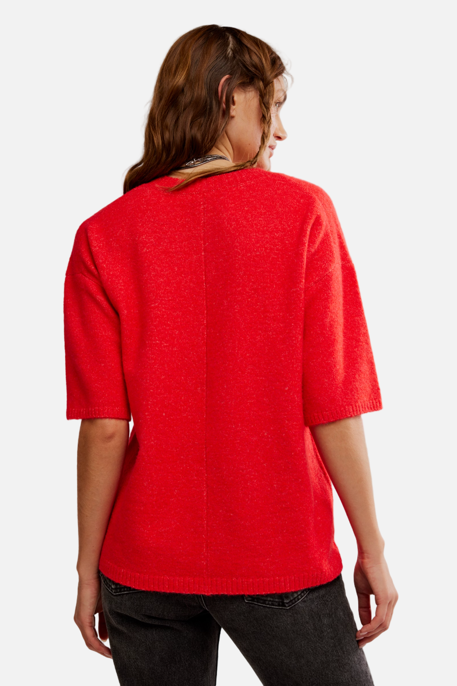 Person wearing a red sweater against a plain background