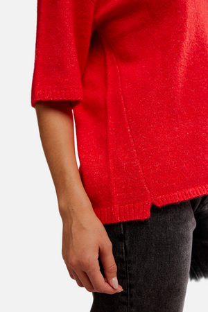 Red sweater worn by a person on a plain background
