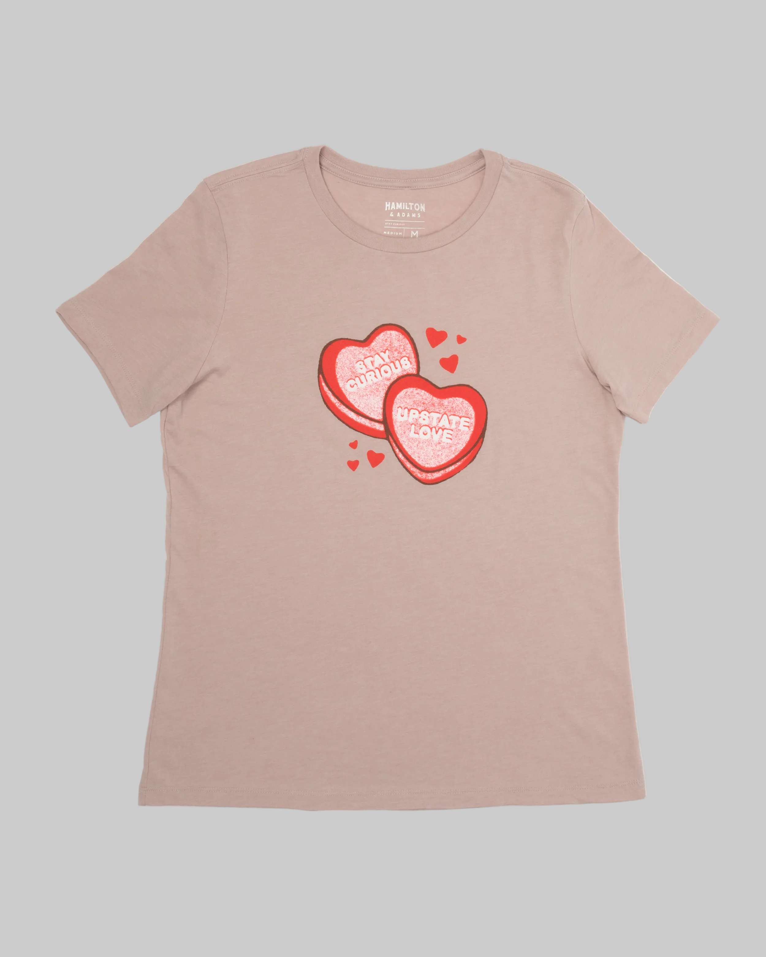 Beige t-shirt with red heart-shaped candy graphic and text on a white background